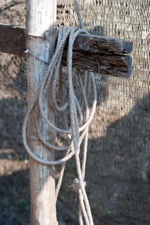 A rope hanging on an old wooden fence in the countryside.