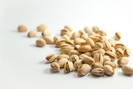 A pile of pistachios on a white floor, selective focus.の写真素材