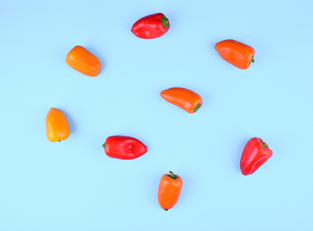 Red, orange, yellow paprika on trendy blue background. Copy space, flat lay style. Colorful diet and healthy food concept.の写真素材