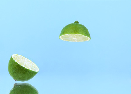 Juicy slices of lime on trendy blue background. Place for your text.の写真素材