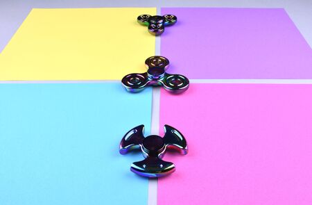 Group of hand fidget spinner toy on colorful and trendy background. Stress and anxiety relief.の写真素材