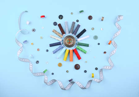 Background with stylish sewing tools and accessories on trendy blue background.
