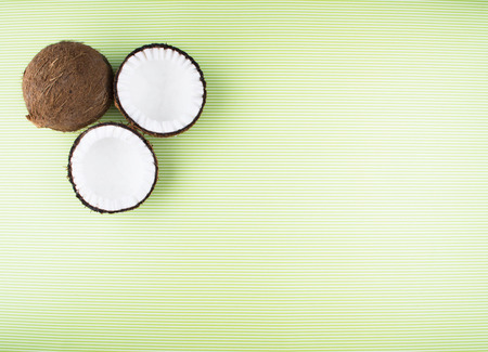 Fruits of coconuts on green background. Colorful diet and healthy eating concept. Flat lay style.の写真素材