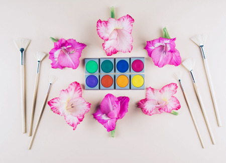 Watercolor and brushes at beige background. Flat lay, top view. Art and education concept.の写真素材