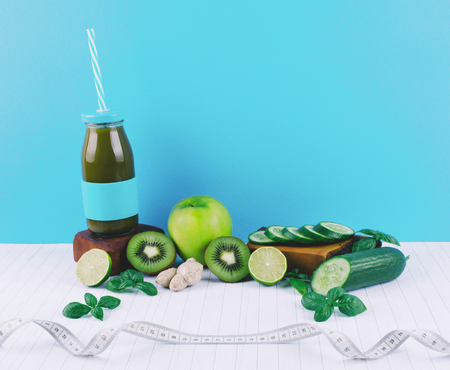Detox diet concept: green smoothie with fruits and vegetables on white wooden table.の写真素材