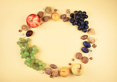 Autumn fruits and nuts on yellow background. Top view, flat lay style.の写真素材