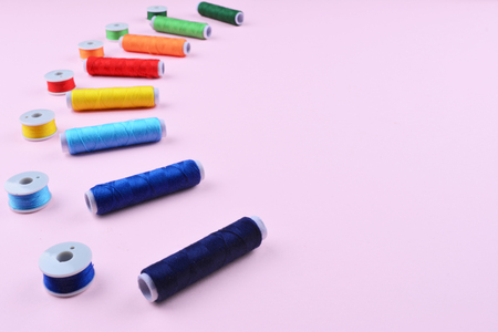 Background with stylish sewing tools and accessories on trendy pink background.