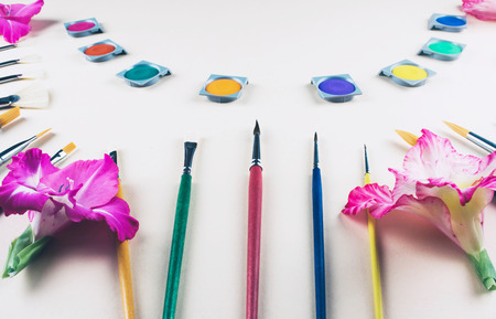 Watercolor and brushes at beige background. Flat lay, top view. Art and education concept.の写真素材
