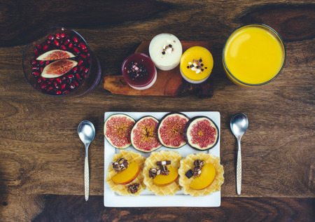 Healthy breakfast set on rustic wooden table. Superfoods smoothies bowl with chia seeds and acai pulver, pomegranate, blackberries, dessert. Overhead, top view, flat lay style.の写真素材