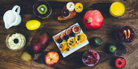 Healthy breakfast set on rustic wooden table. Superfoods smoothies bowl with chia seeds and acai pulver, pomegranate, blackberries, dessert. Overhead, top view, flat lay style.の写真素材