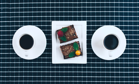 Cup of coffee with homemade vegan cake brownies. Flat lay styleの写真素材