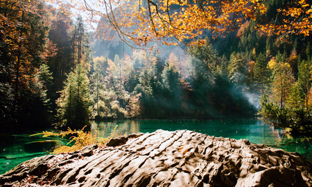 Autumn time at romantic forest lake blausee, one of the best known mountain lakes in Switzerland.