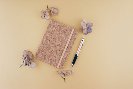 Still life business office supplies or education concept. Top view image of notebook with with pen and dry flowers.の写真素材