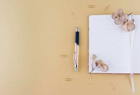 Still life business office supplies or education concept. Top view image of notebook with with pen and dry flowers.の写真素材