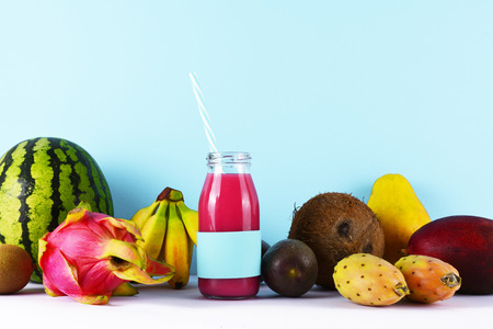Healthy lifestyle concept: pink smoothie with tropical fruits on white table.の写真素材