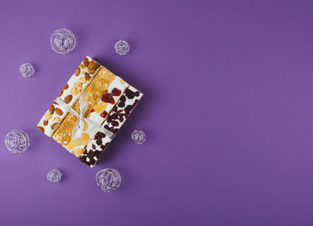 Traditional italian festive torrone or nougat with nuts on lilac background.の写真素材