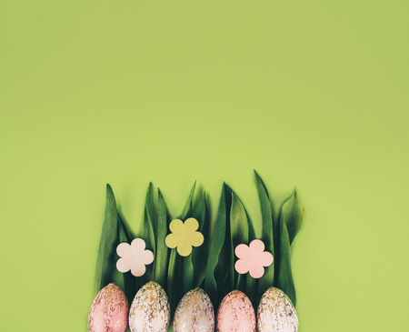 Creative easter composition with painted eggs against green background with space for your text.の写真素材