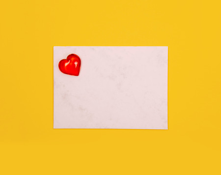 Red heart against yellow background.の写真素材