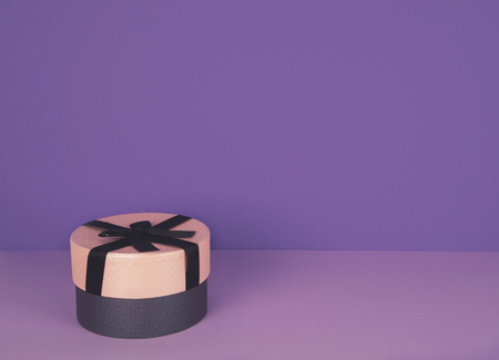 Pink gift box against ultra violet and lilac background with copy space. Color of the year.