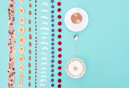 Breakfast with berries and nuts on mint background, copy space.の写真素材