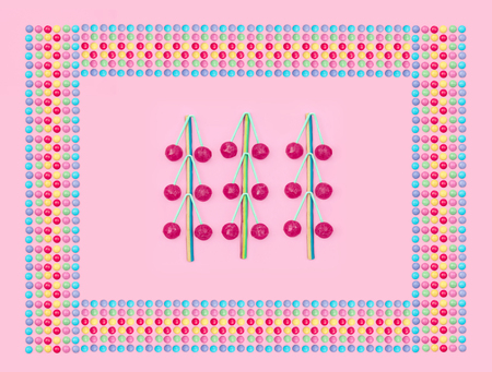 Assorted colored candies on pink background.