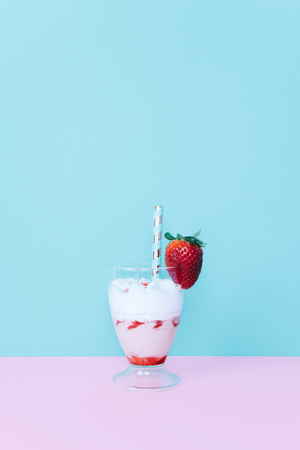 Milkshake with straw and strawberry.の写真素材