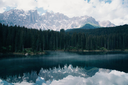 The Karersee lake with reflection of mountains in the Dolomites.
