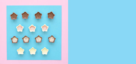 Chocolate pralines on pink and blue background.