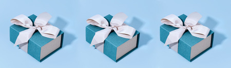 Pattern made of blue gift boxes on pastel background.