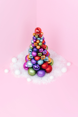 Christmas tree made of pink decoration on pink background. Xmas and holiday concept.の写真素材