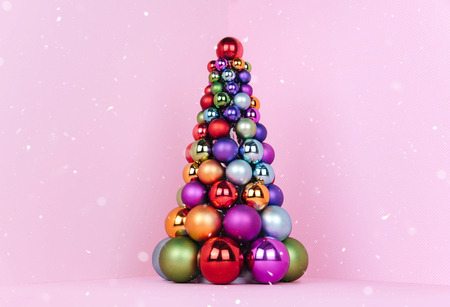 Christmas tree made of pink decoration on pink background. Xmas and holiday concept.の写真素材