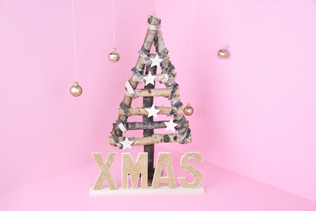 Christmas tree over light pink background. Xmas and holiday concept.の写真素材