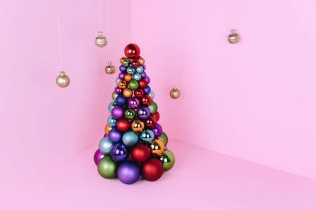Christmas tree made of pink decoration on pink background. Xmas and holiday concept.の写真素材