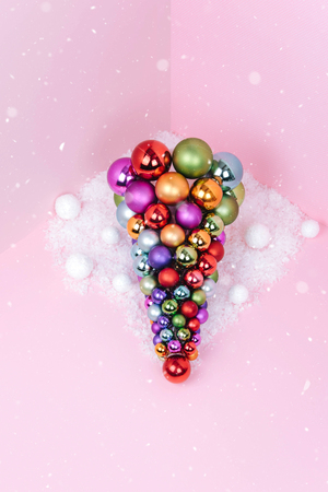 Christmas tree made of pink decoration on pink background. Xmas and holiday concept.の写真素材