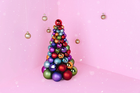 Christmas tree made of pink decoration on pink background. Xmas and holiday concept.の写真素材