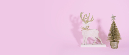 Christmas wooden tree with reindeer over pink background. Xmas and holiday concept.の写真素材