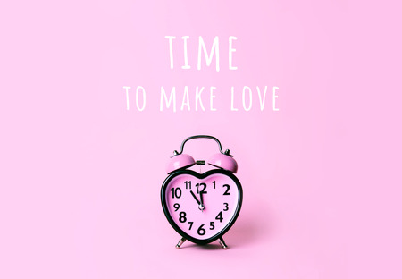 Heart shaped clock on pink background. Valentines day and love and duration concept.の写真素材