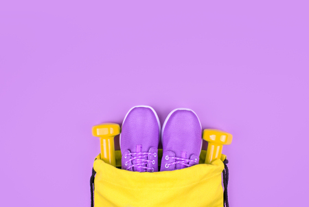 Creative flat lay of sport and fitness equipments on violet background with copy space.の写真素材
