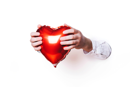 Hands holding a heart on white background. Creative minimal concept.の写真素材