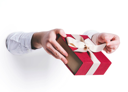 Man holding a gift box on white background.の写真素材
