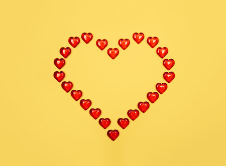 Red heart against yellow background. Valentine s day theme with copy space.の写真素材