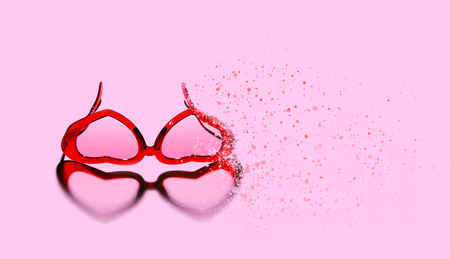 A pair of red heart shaped sun glasses on pink background.の写真素材