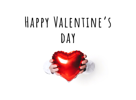 Hands holding a heart on white background. Creative minimal concept.の写真素材