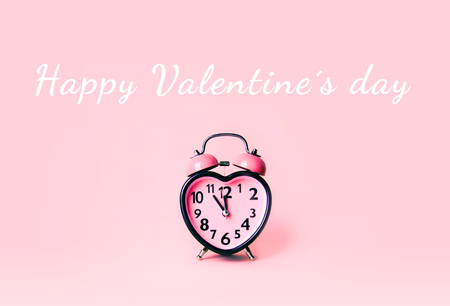 Heart shaped clock on pink background. Valentines day and love and duration concept.の写真素材