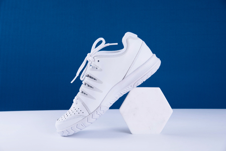 Pair of white sneakers on blue background. Healthy lifestyle concept.の写真素材
