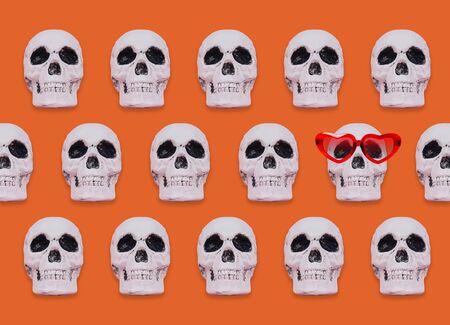 Skull pattern on orange background. Creative Halloween concept.の写真素材