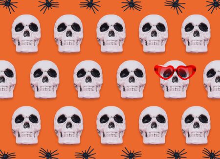 Skull pattern on orange background. Creative Halloween concept.の写真素材
