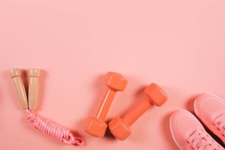 Creative flat lay of sport and fitness equipments on Living Coral background. Color of the year.の写真素材