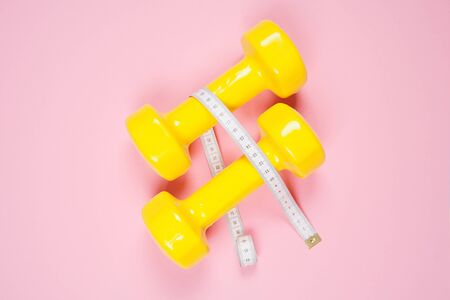 Flat lay shot of dumbbells on pink background. Sport concept.の写真素材