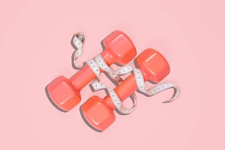 Flat lay shot of dumbbells on pink background. Sport concept.の写真素材